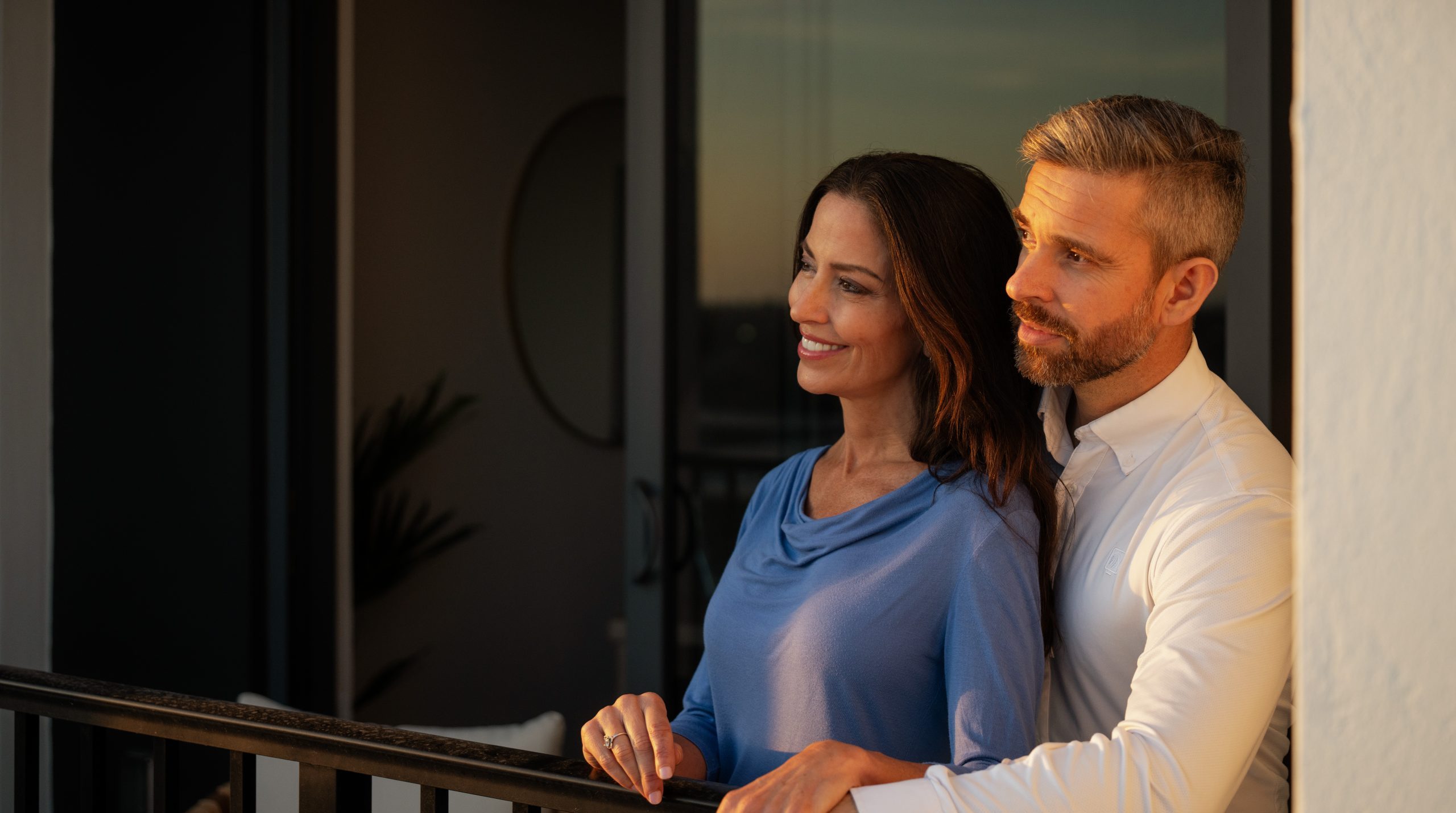 Man and woman look into the sunset from an apartment balcony at VIV St Pete.